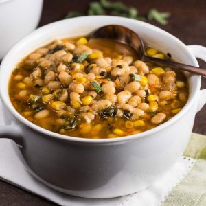 A white bowl of sage and white bean soup.