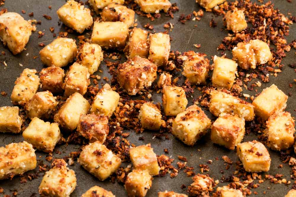 A baking sheet filled with crispy sesame tofu croutons
