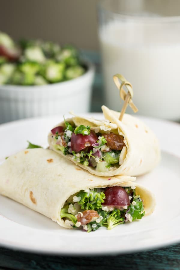 Broccoli Quinoa Salad wrapped up in a tortilla on a white plate.