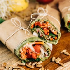 Sunflower Hummus Wraps on a cutting board with sunflower seeds on the side.