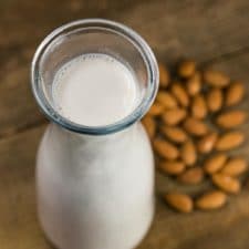 homemade almond milk with almonds in the background