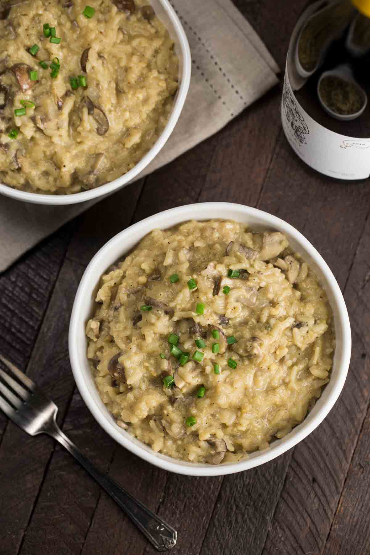 Instant Pot Vegan Mushroom Risotto in a white bowl with a fork on the side.