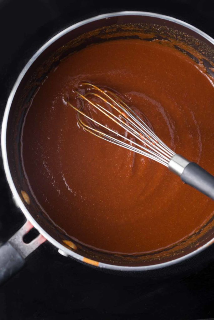 BBQ sauce in a pot being heated on the stovetop.