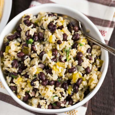 Black beans and rice in a white bowl on a colorful napkin