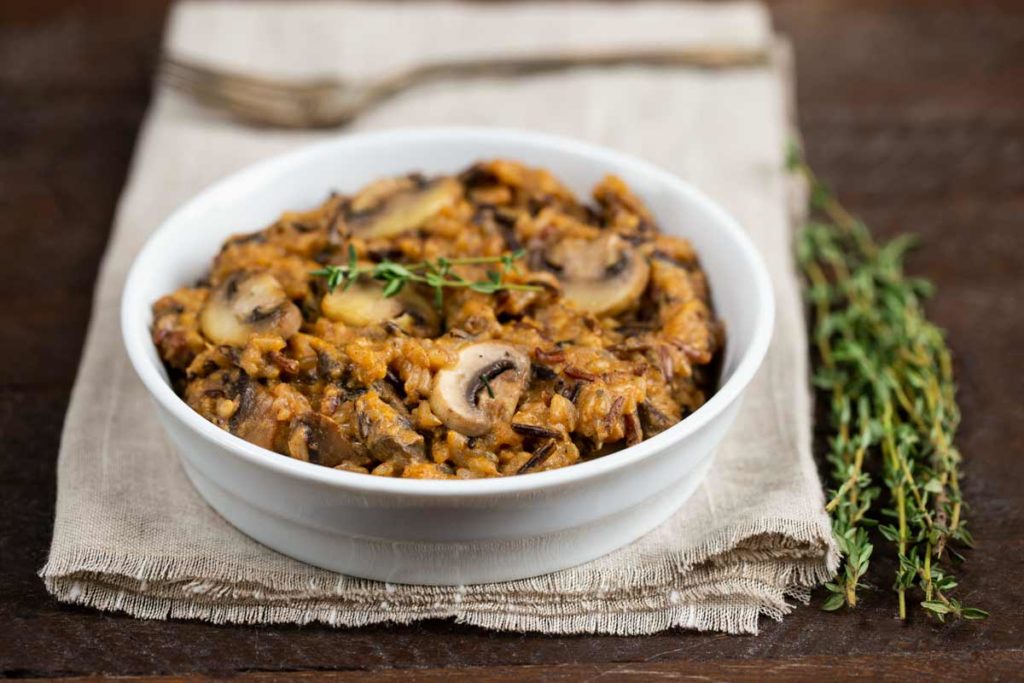 A white bowl filled with Instant Pot Wild Rice with mushrooms.