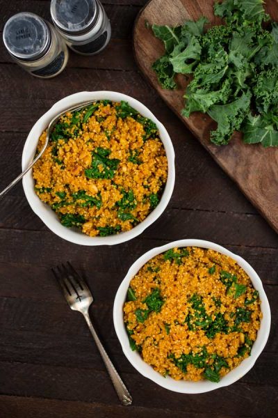 Two bowls of kale quinoa with fork and kale on the side