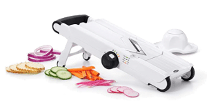 A mandoline with veggies on the side.